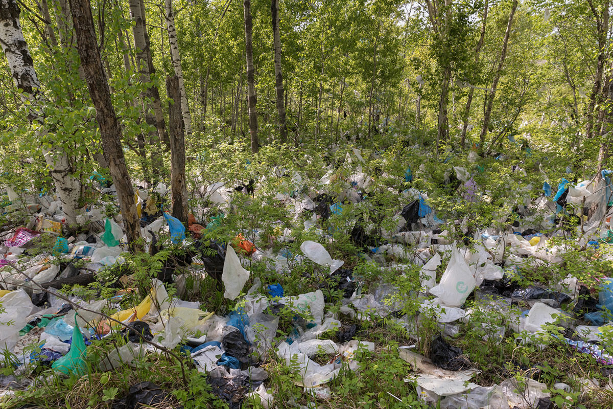 Sampah plastik tersebar di hutan dekat tempat pembuangan sampah liar dekat Khabarovsk, Rusia, 27 Mei 2018