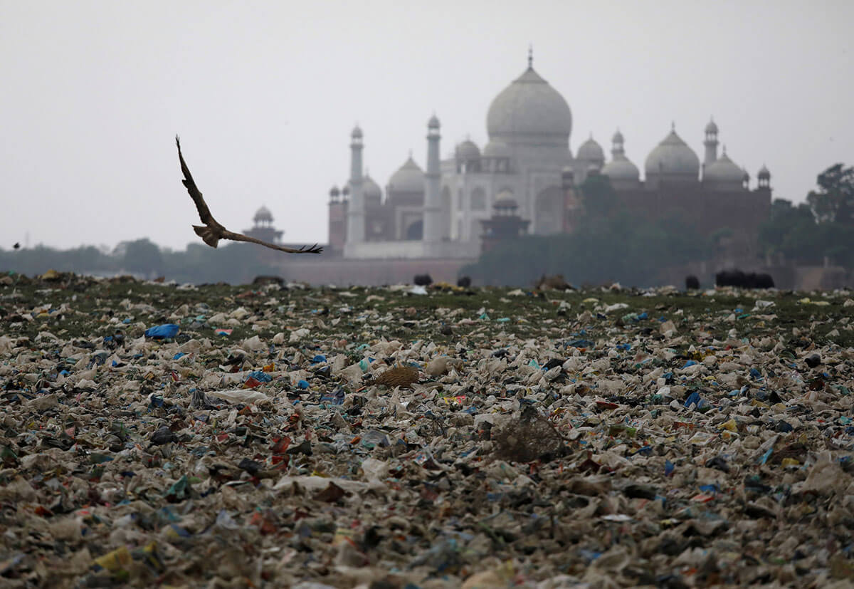 Sampah plastik tersebar di seberang sungai Yamuna yang tercemar di dekat bangunan bersejarah Taj Mahal di Agra, India, 19 Mei 2018